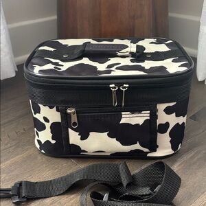 Cow  print zip close,interior mirror,brush slots, handle & strap,zip pocket